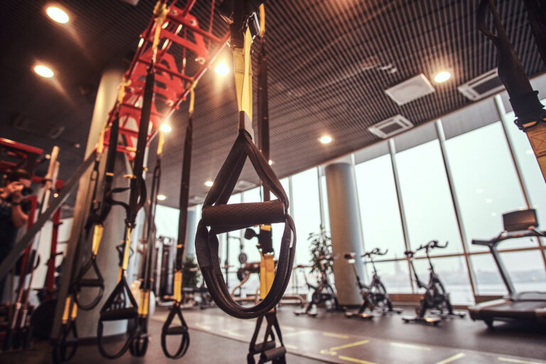 interior and equipment in the modern gym, close up view of suspension straps